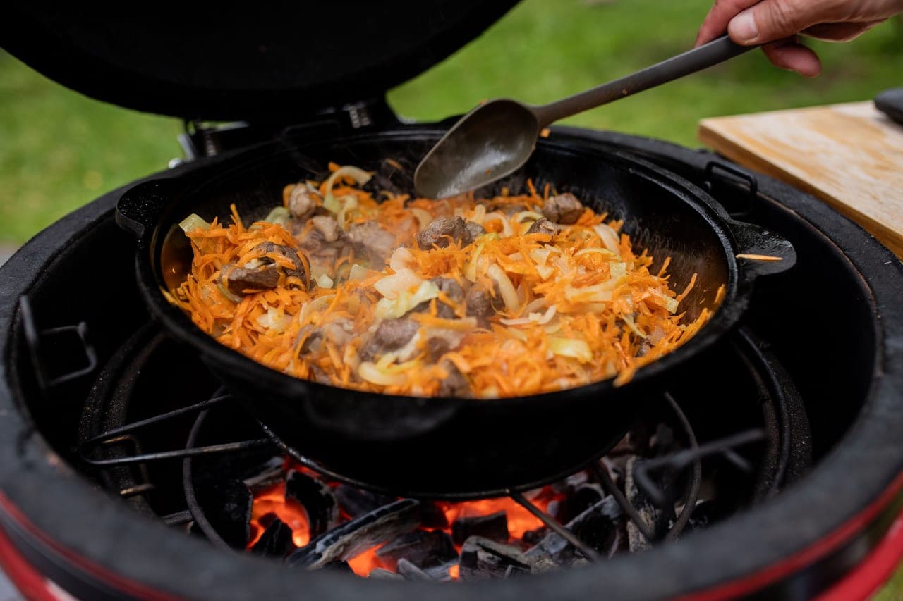 A ceramic kamado grill with glowing charcoal
