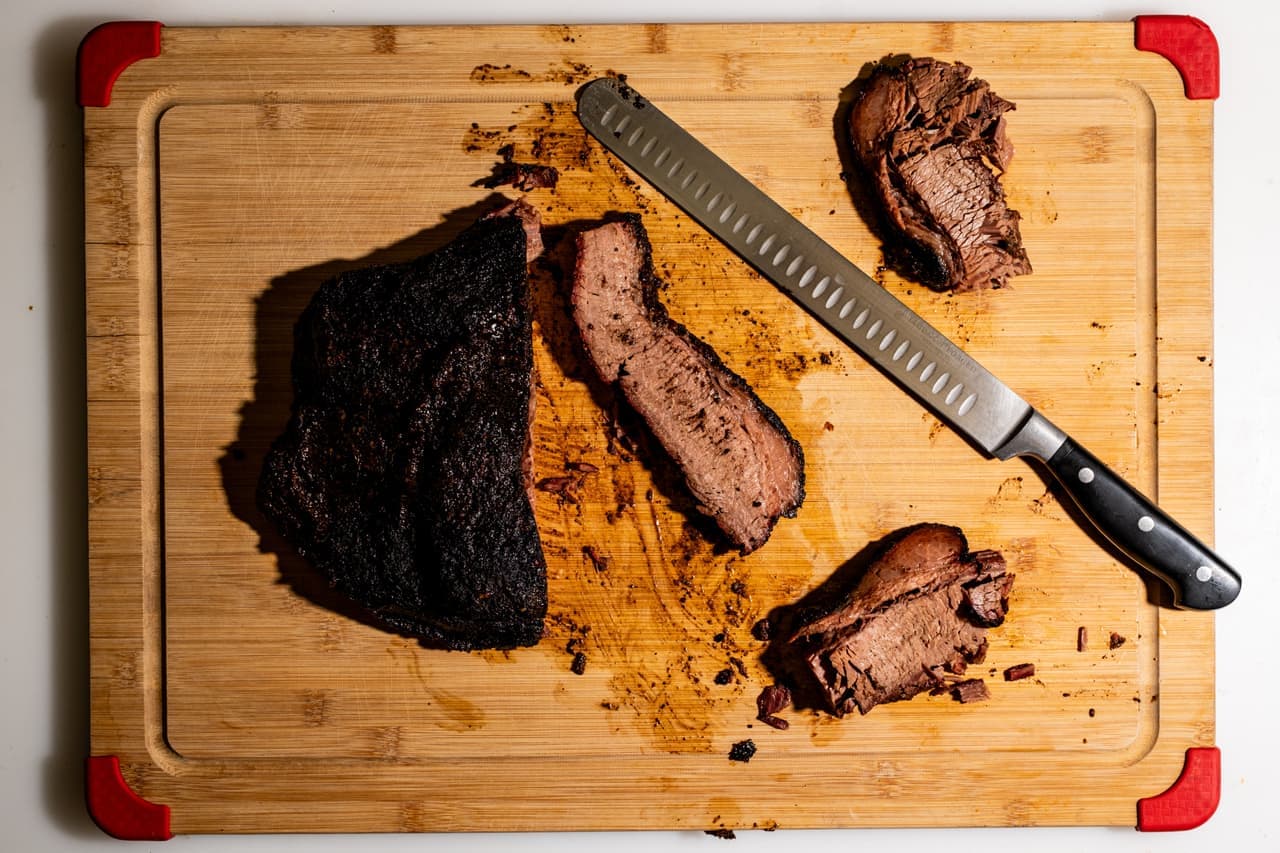 Brisket smoking low and slow over wood coals in a barbecue smoker